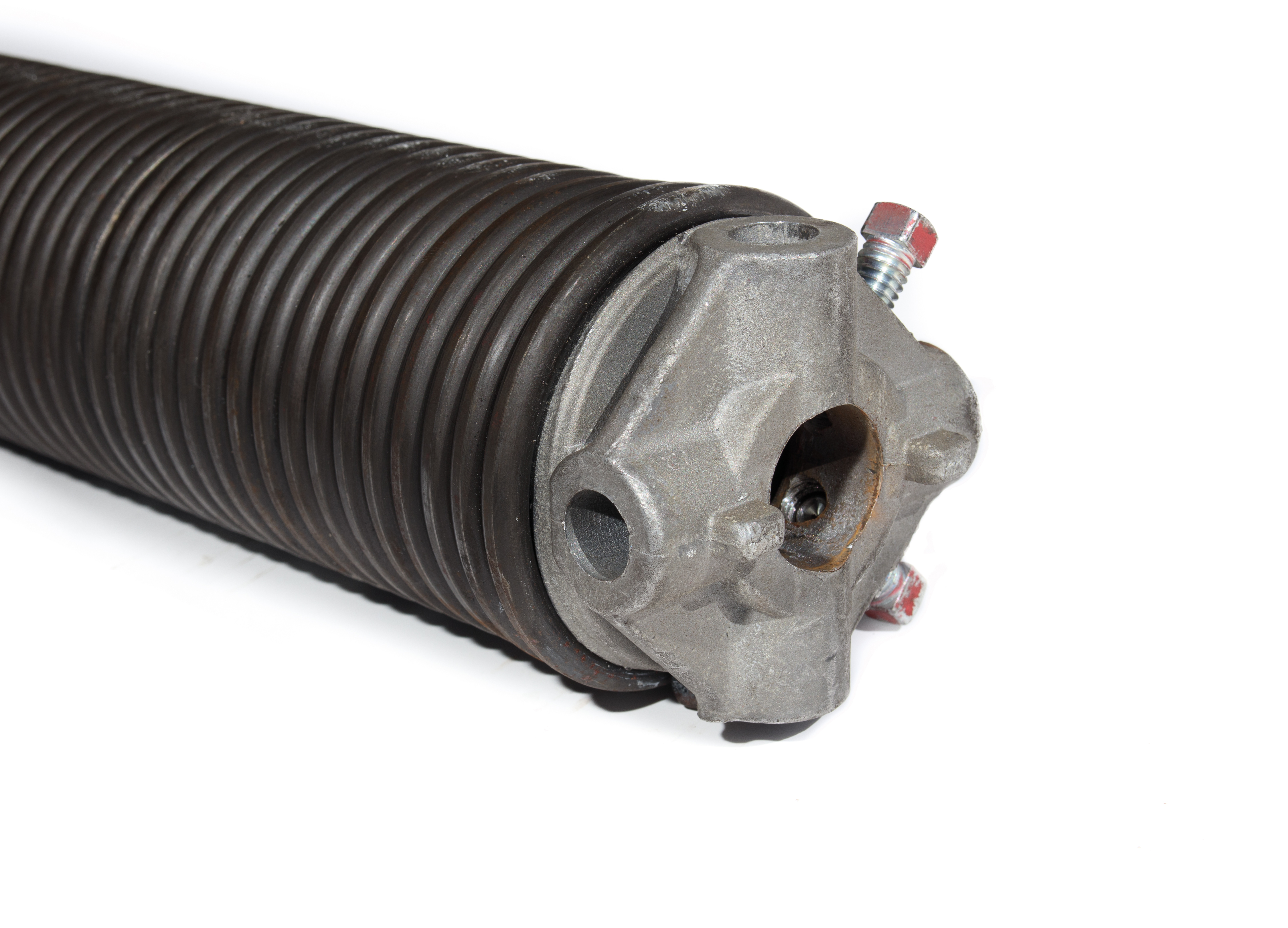 Torsion spring mounted on a shaft above the door
